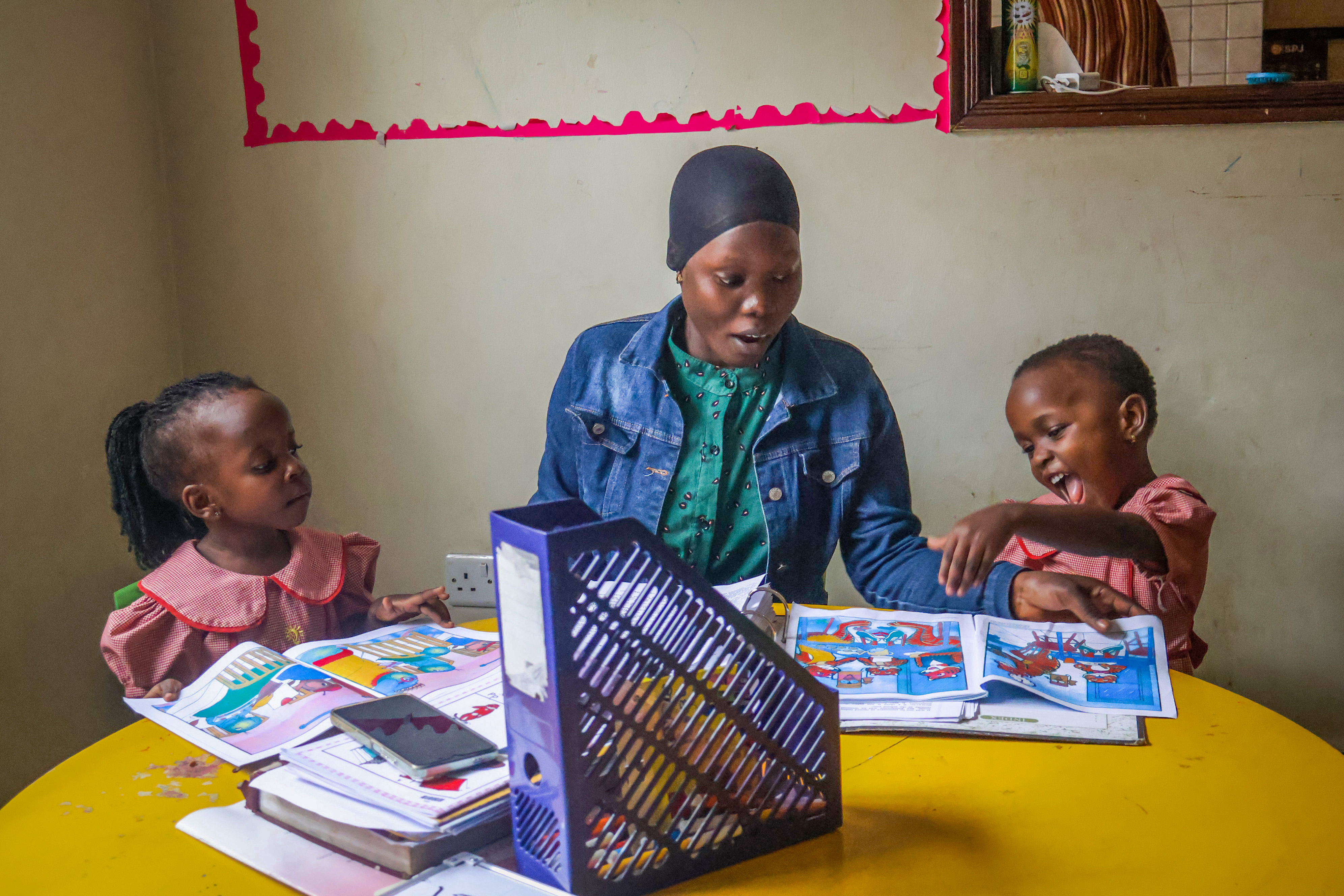 Teacher sharing a laugh with learners during a reading activity
